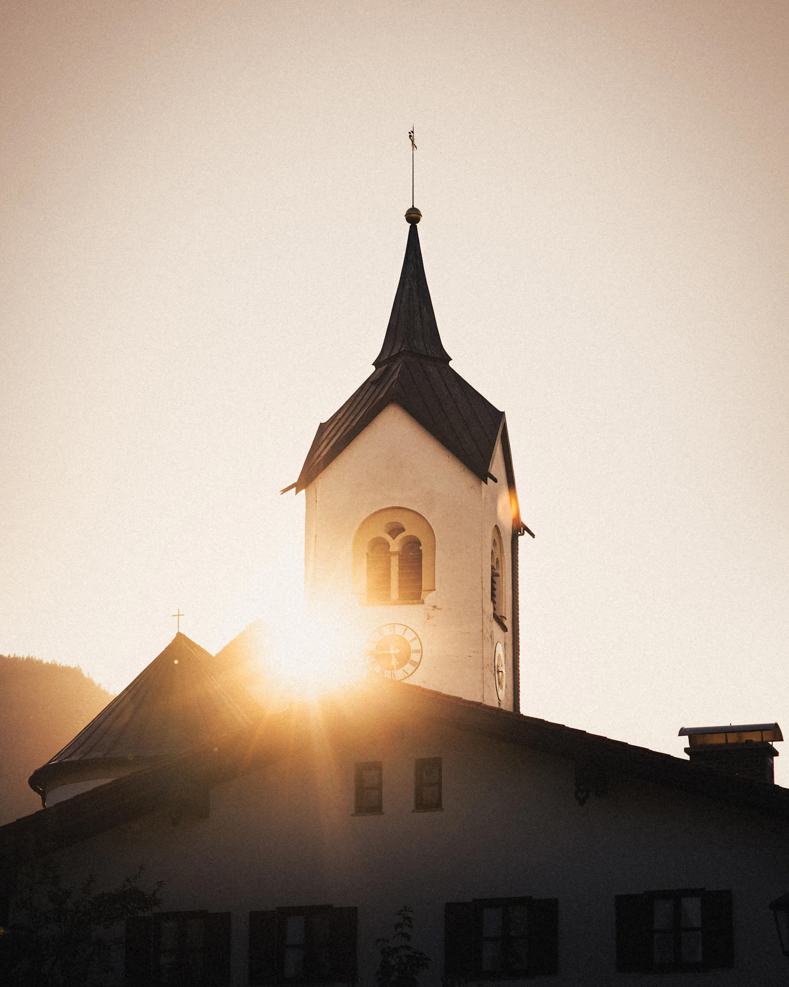 A church tower and roof in warm evening light.
