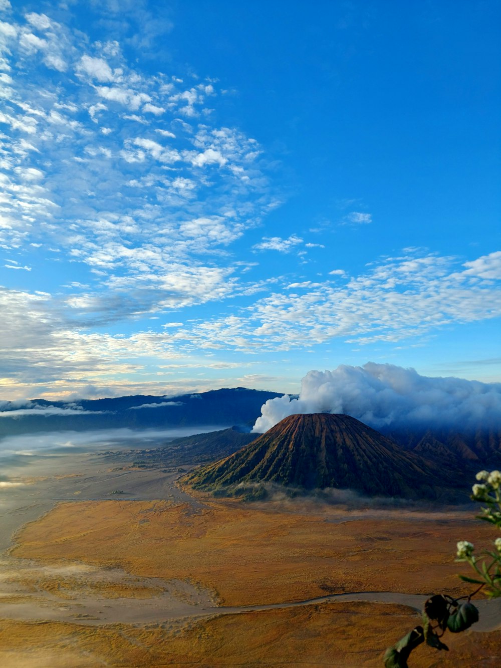 a view of a mountain with clouds in the sky