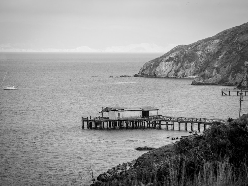 a black and white photo of a pier and a boat