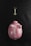 A pink piggy bank with white polka dots lying on a dark textured surface, accompanied by a golden key placed above it.