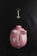 A pink piggy bank with white polka dots lying on a dark textured surface, accompanied by a golden key placed above it.