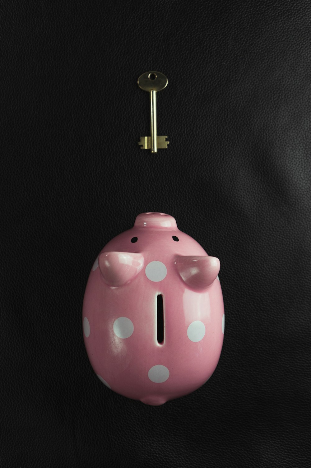 a pink piggy bank with a key hanging from it