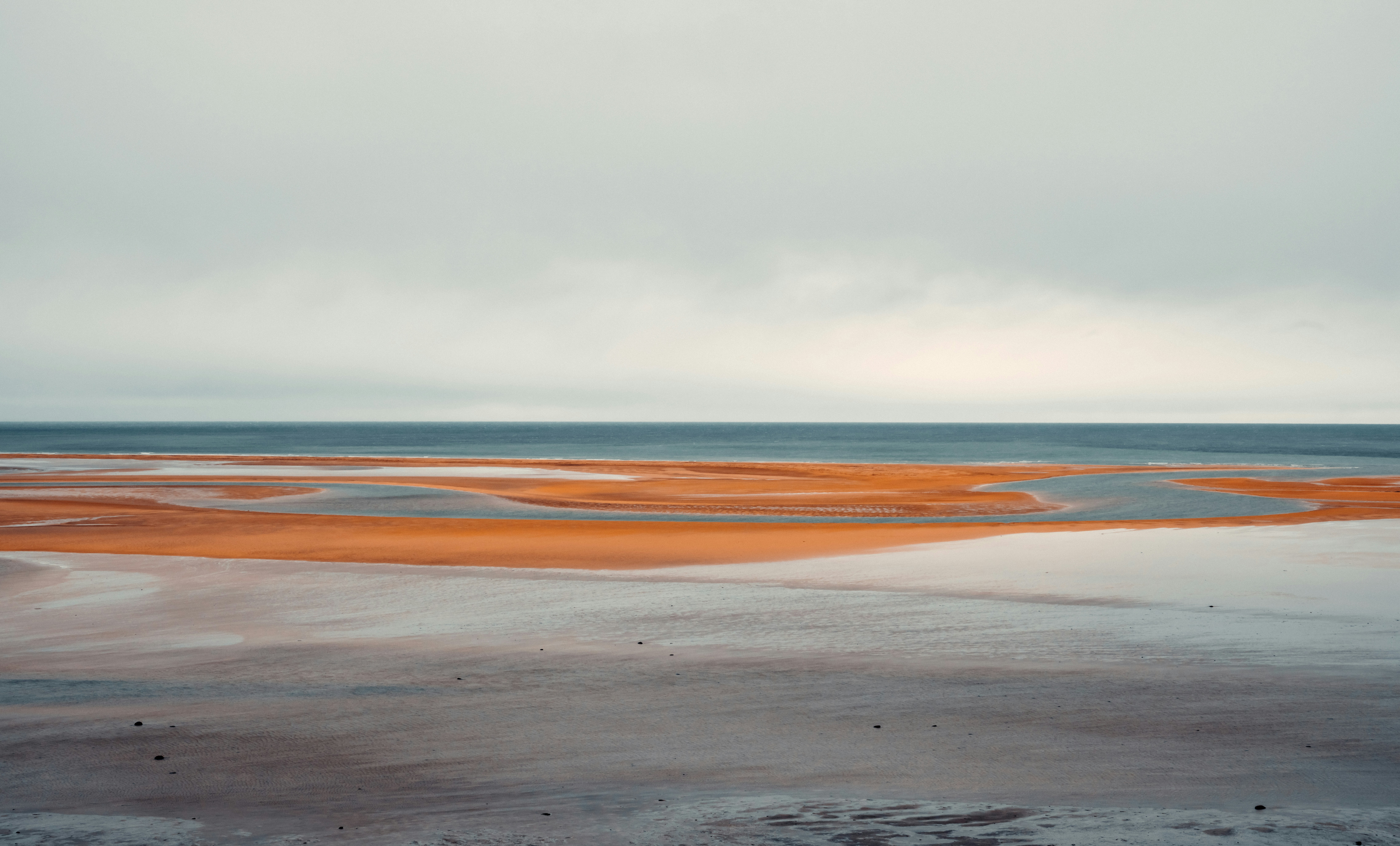 a large body of water sitting on top of a sandy beach, 