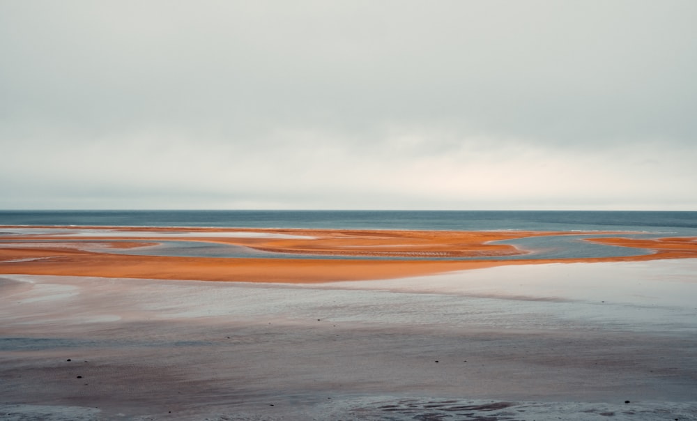 a large body of water sitting on top of a sandy beach