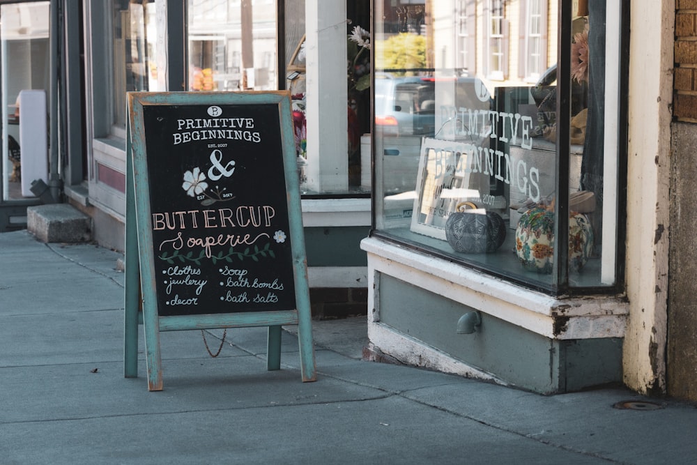 a chalkboard sign on a sidewalk in front of a store