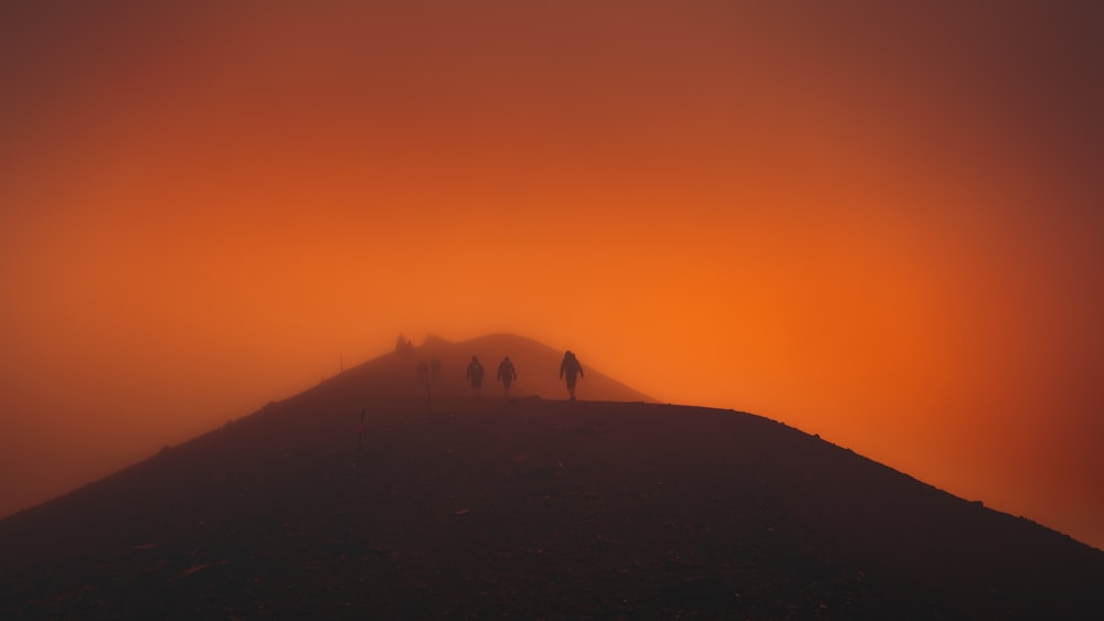 un groupe de personnes debout au sommet d’une colline