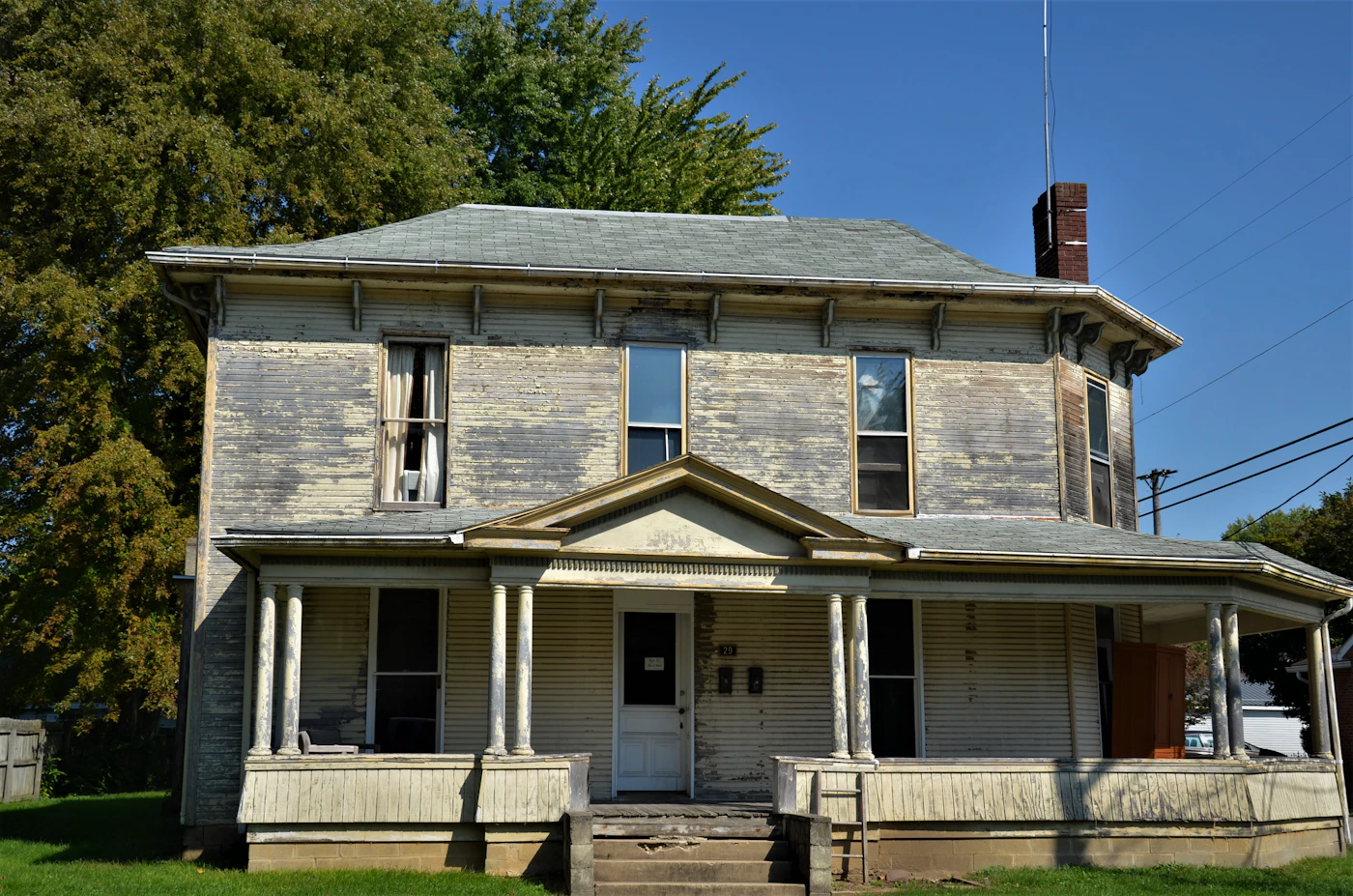 Older traditional family home with weathered porch