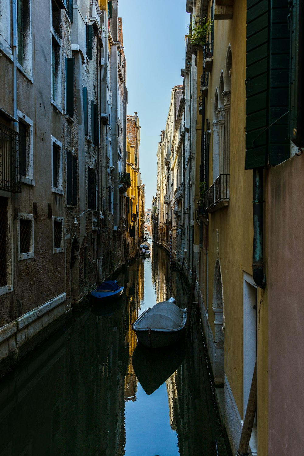 a boat is floating down a narrow canal