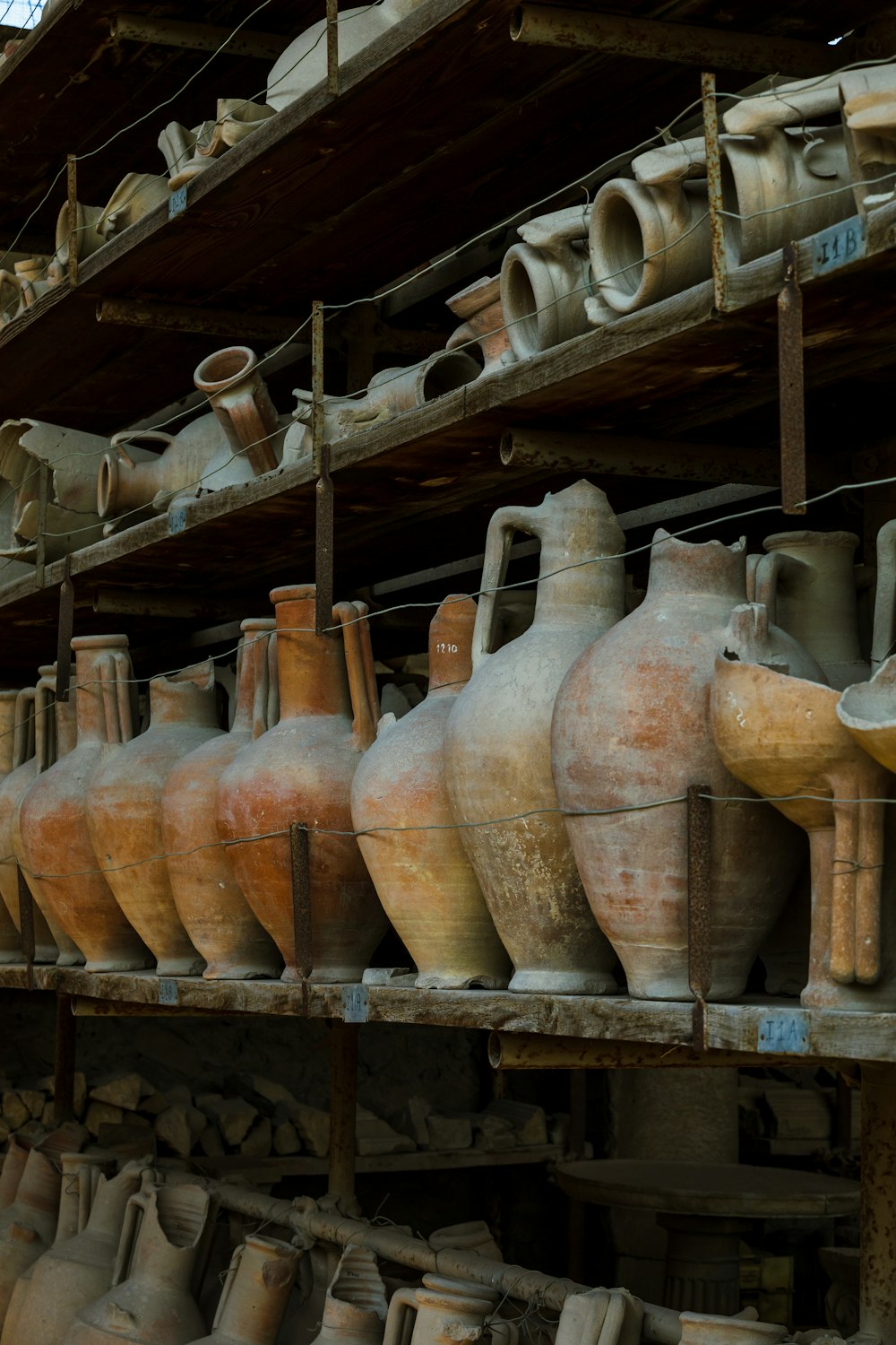 a shelf filled with lots of clay vases