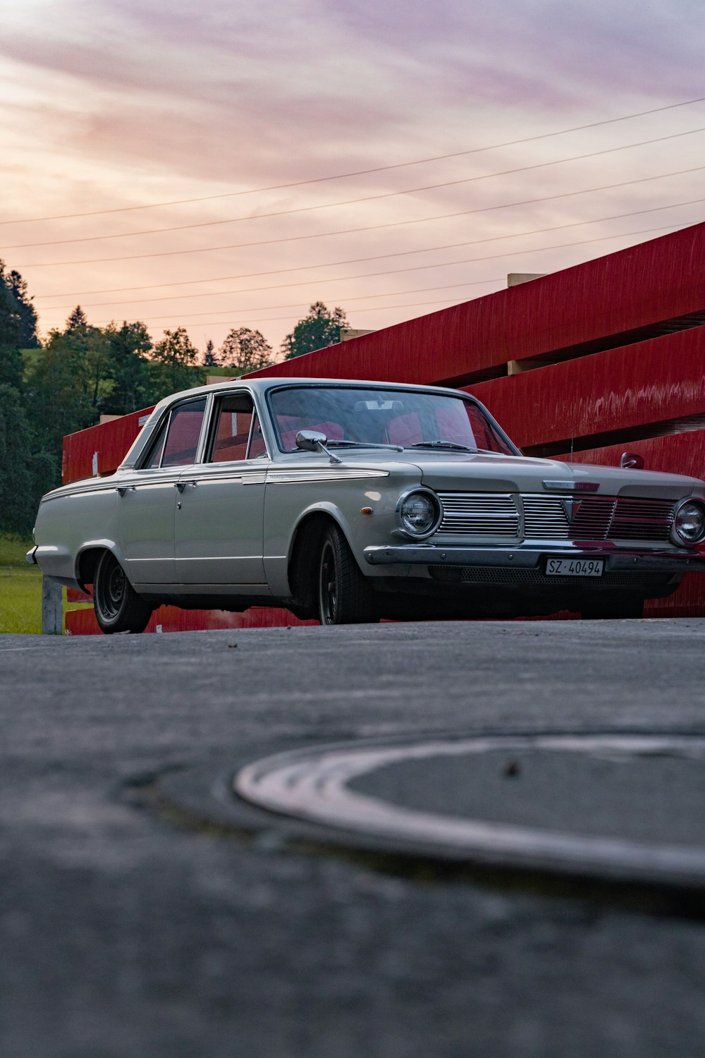 a classic car parked in front of a red building