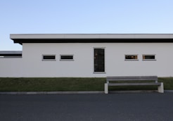 a bench sitting in front of a white building