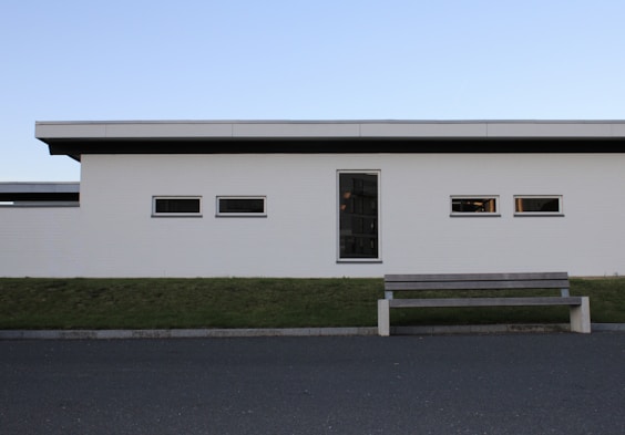 a bench sitting in front of a white building