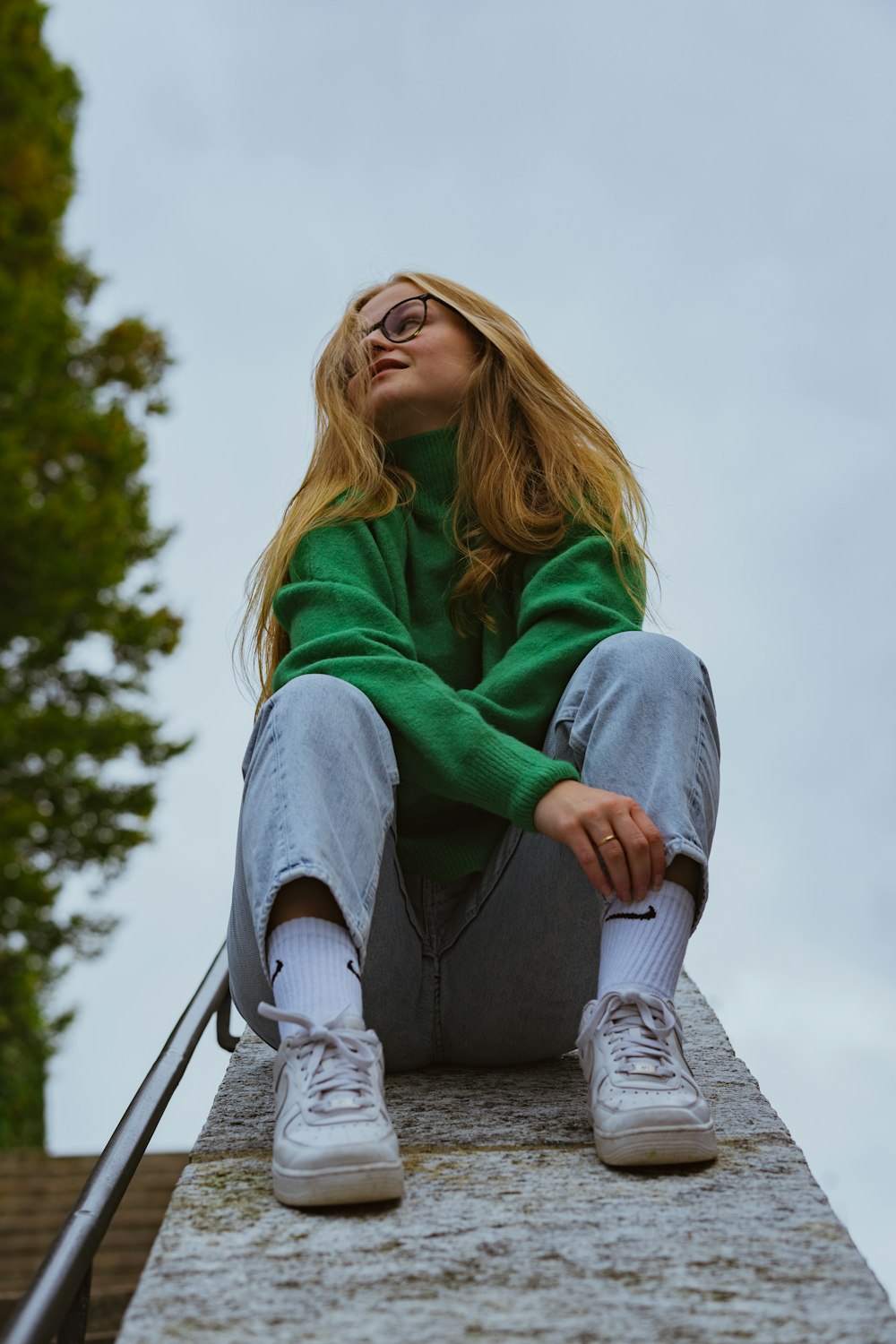 a woman sitting on top of a cement structure