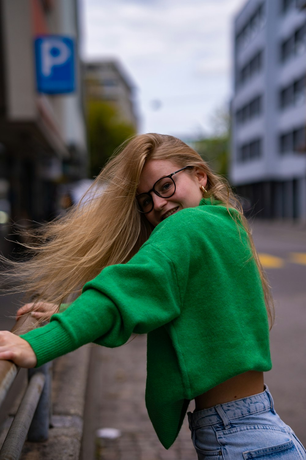 a woman leaning on a rail with her hair blowing in the wind