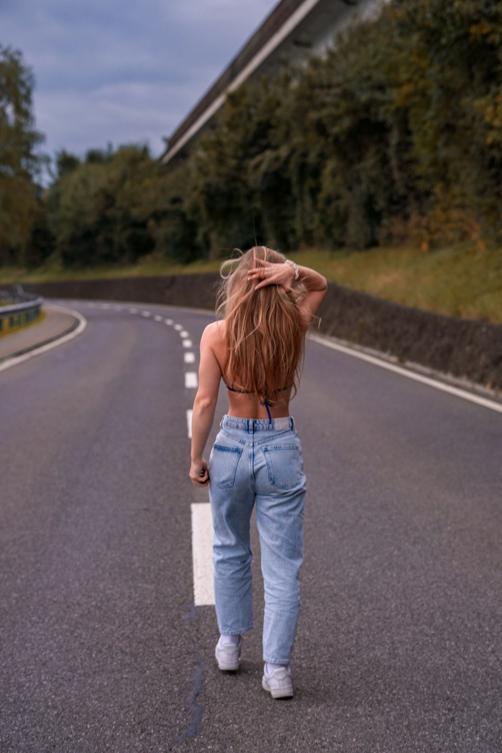 a woman walking down the middle of a road