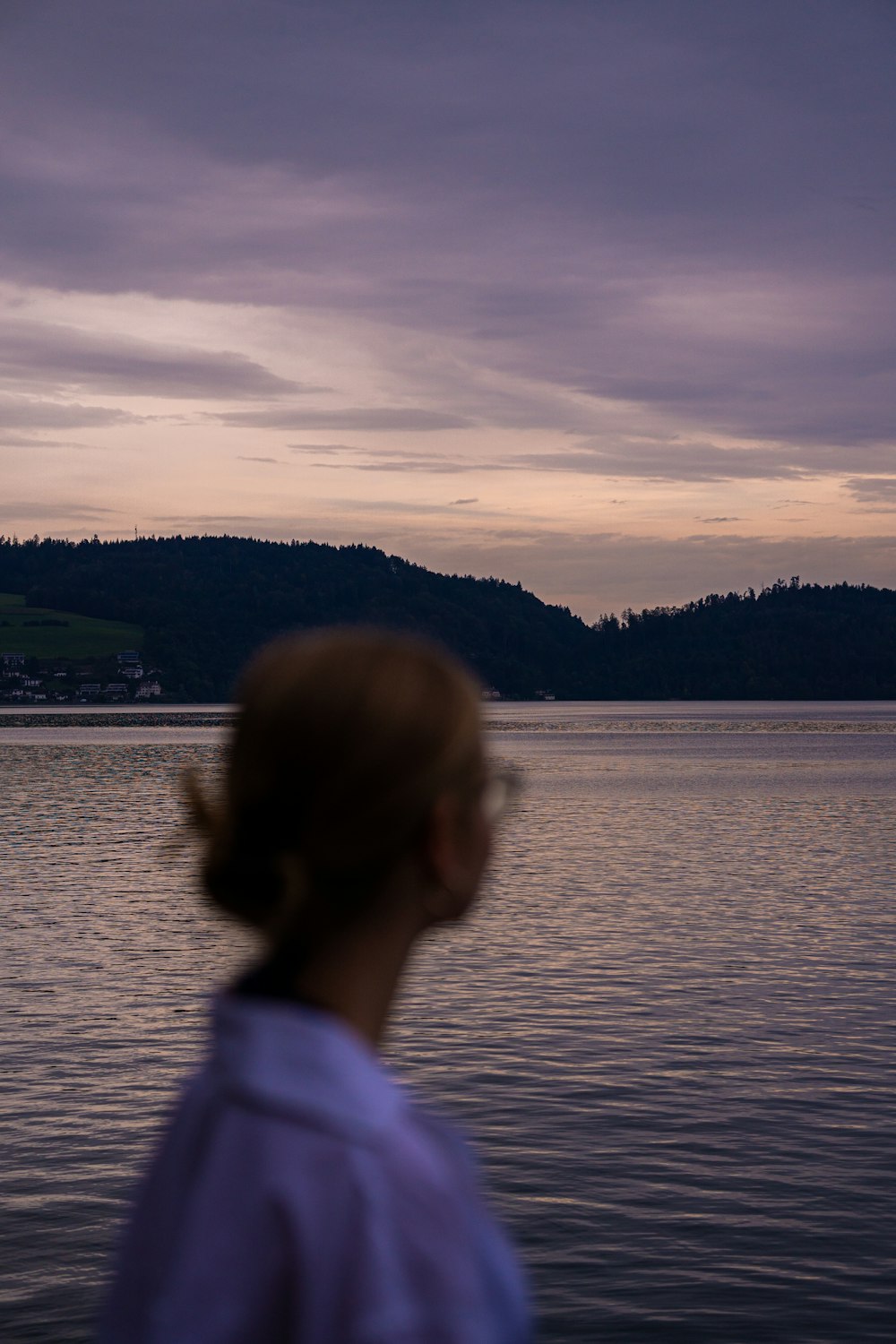 a woman standing in front of a body of water