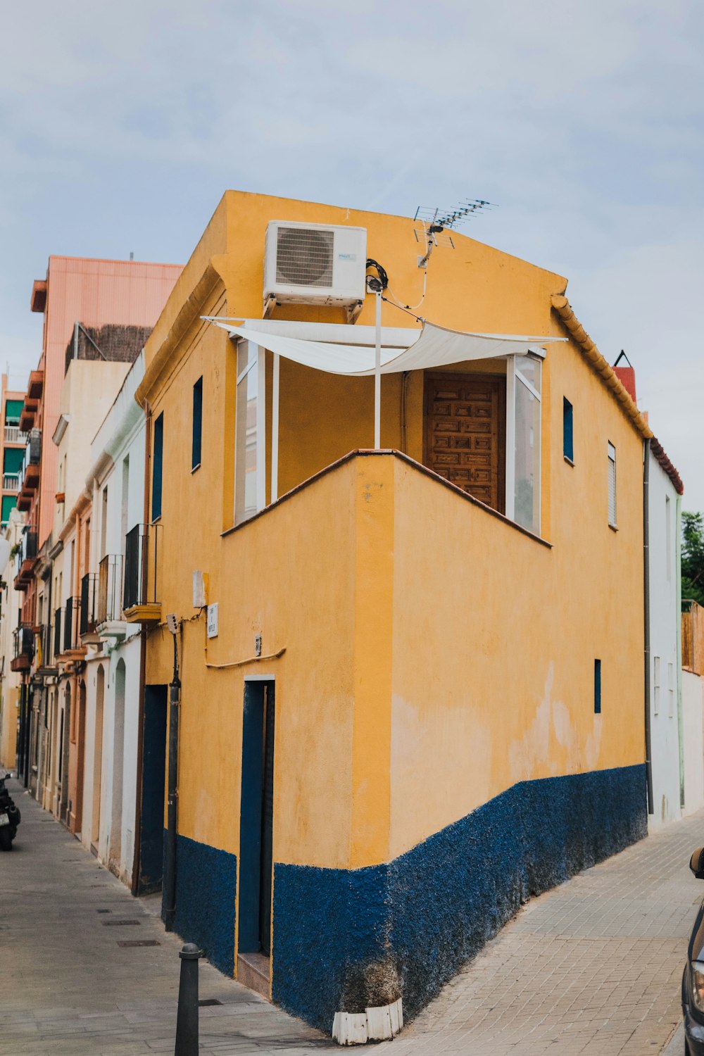 a yellow building with a blue and white roof