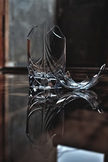 A broken object being carefully examined on a wooden table with tools around.