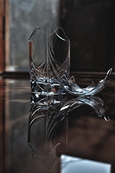 A broken object being carefully examined on a wooden table with tools around.