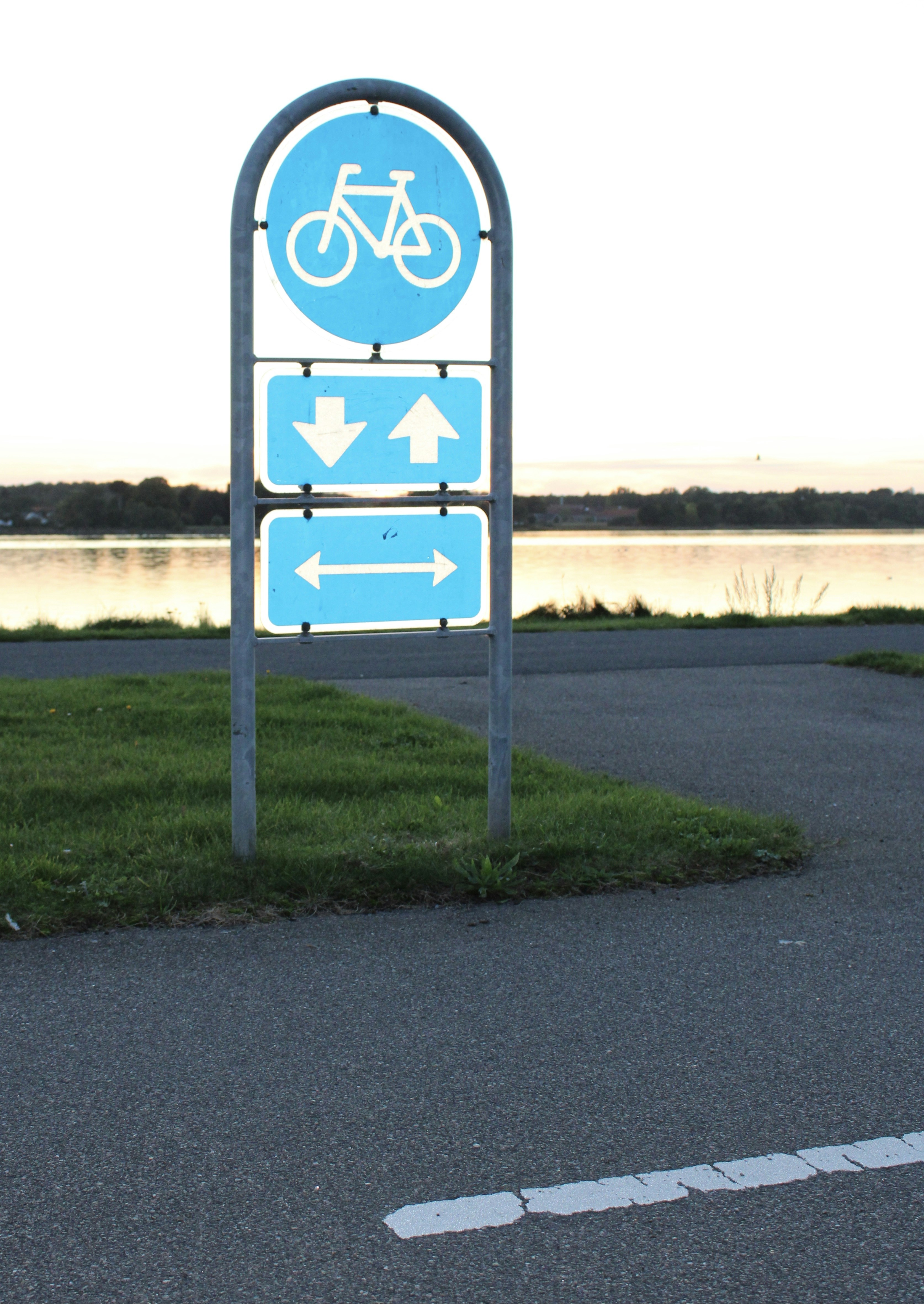 a blue sign sitting on the side of a road