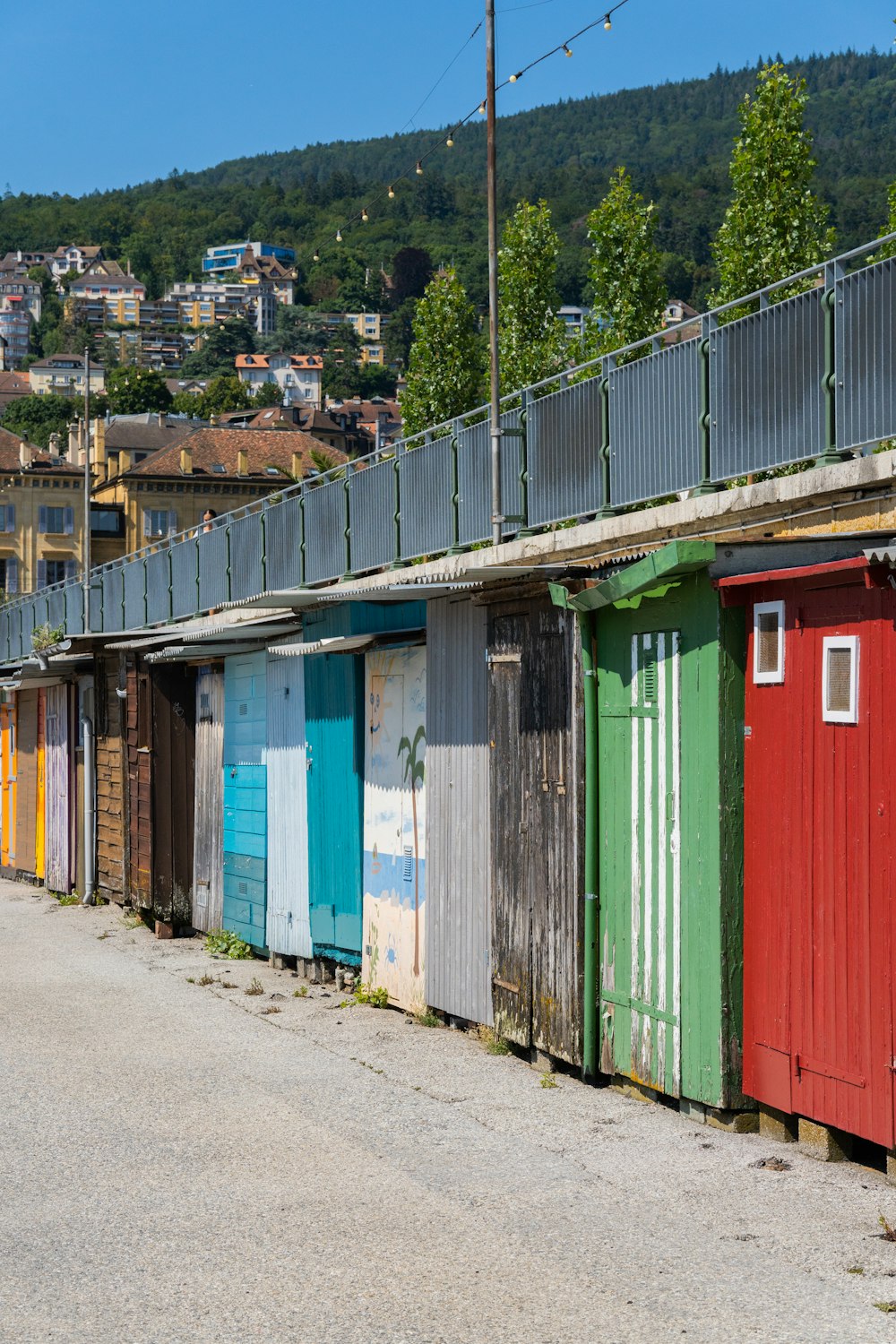a row of colorful beach huts next to a road