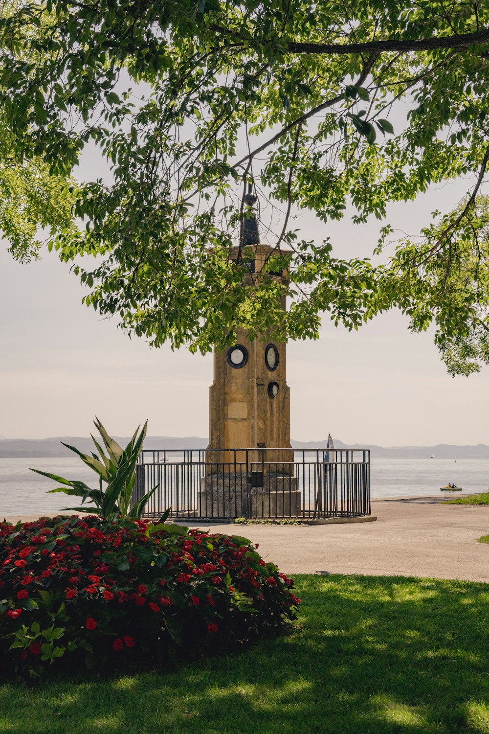 a clock tower sitting in the middle of a lush green field