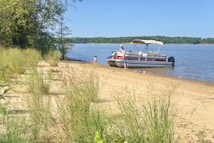 a boat is parked on the shore of a lake