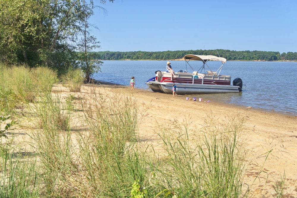 a boat is parked on the shore of a lake