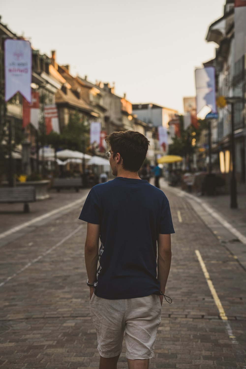 a man walking down a street next to tall buildings