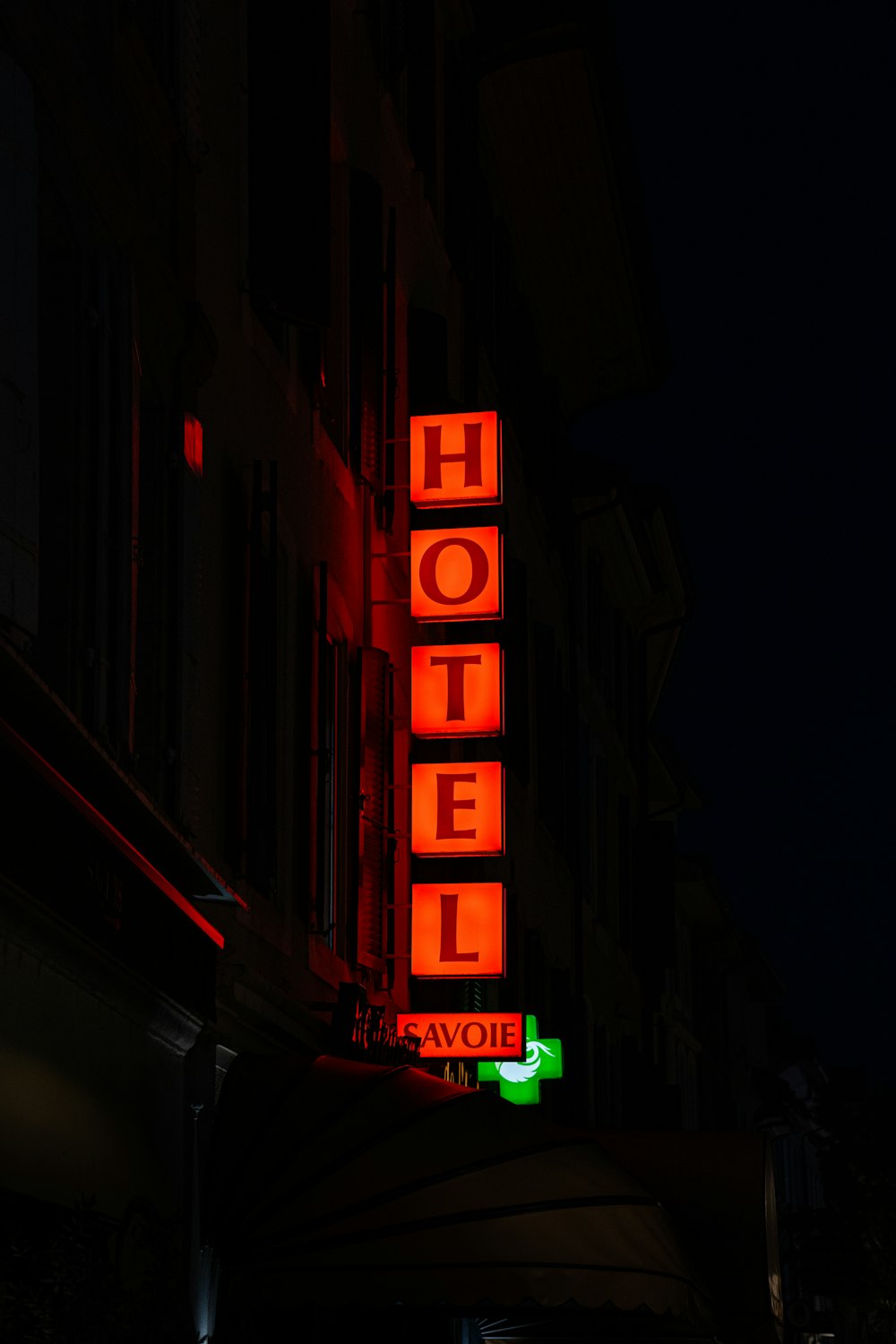 a neon hotel sign lit up at night