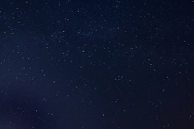 the night sky is full of stars and a few clouds