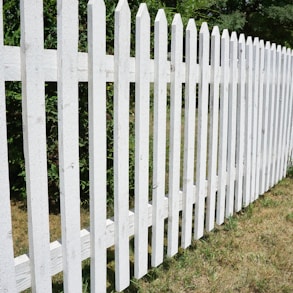 a white picket fence in a grassy area