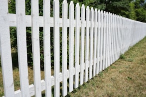 a white picket fence in a grassy area