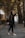 a woman walking down a road in a black jacket