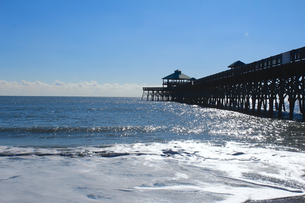 a pier on the ocean with waves coming in