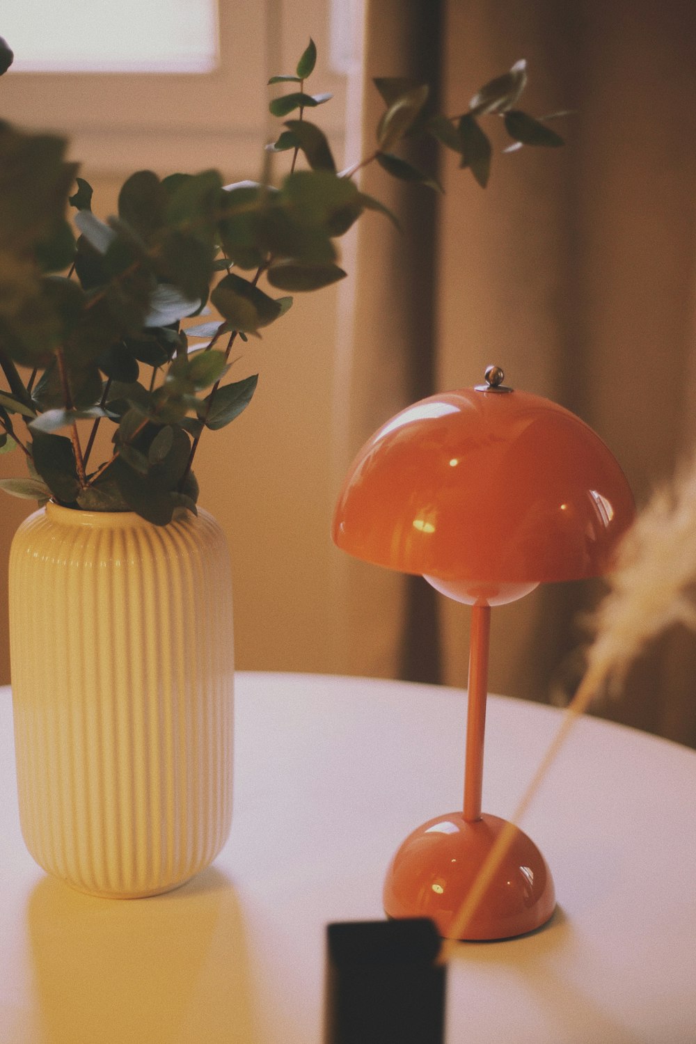 a table with a lamp and a potted plant on it