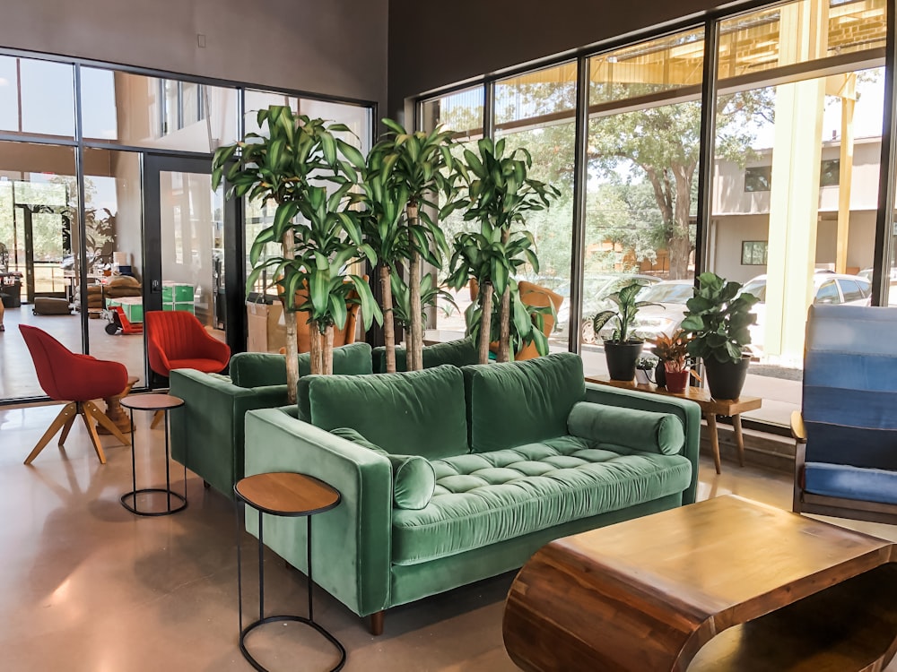 a living room filled with lots of green furniture