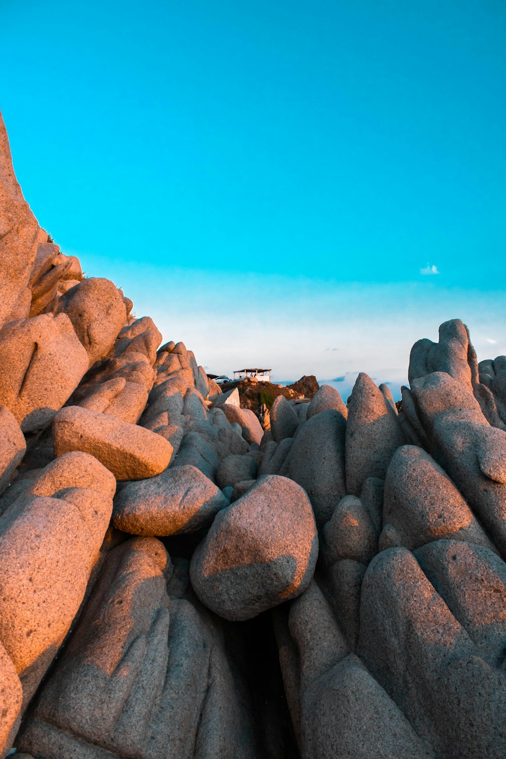 une grande formation rocheuse avec un ciel bleu en arrière-plan