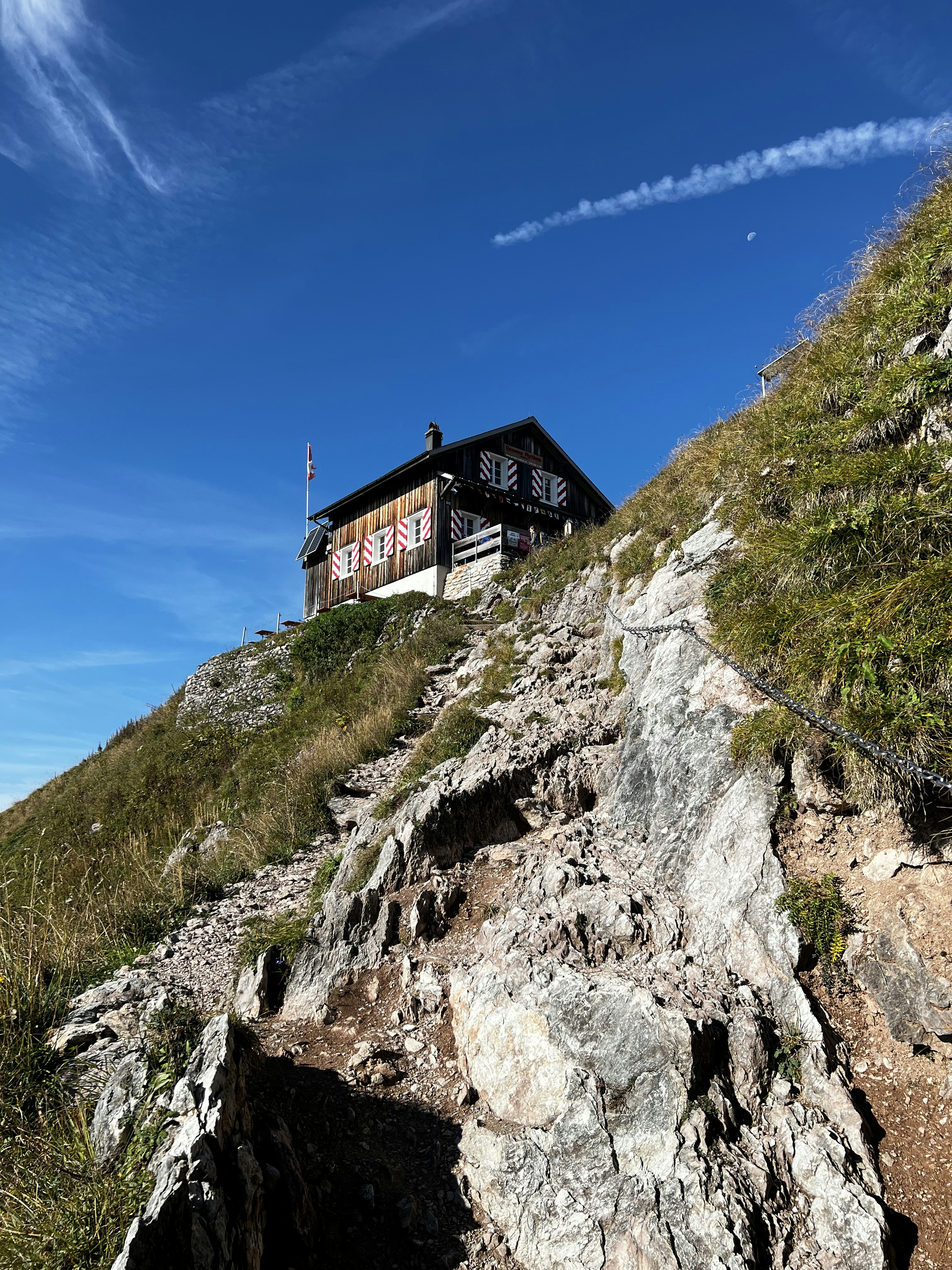a house sitting on top of a rocky hill