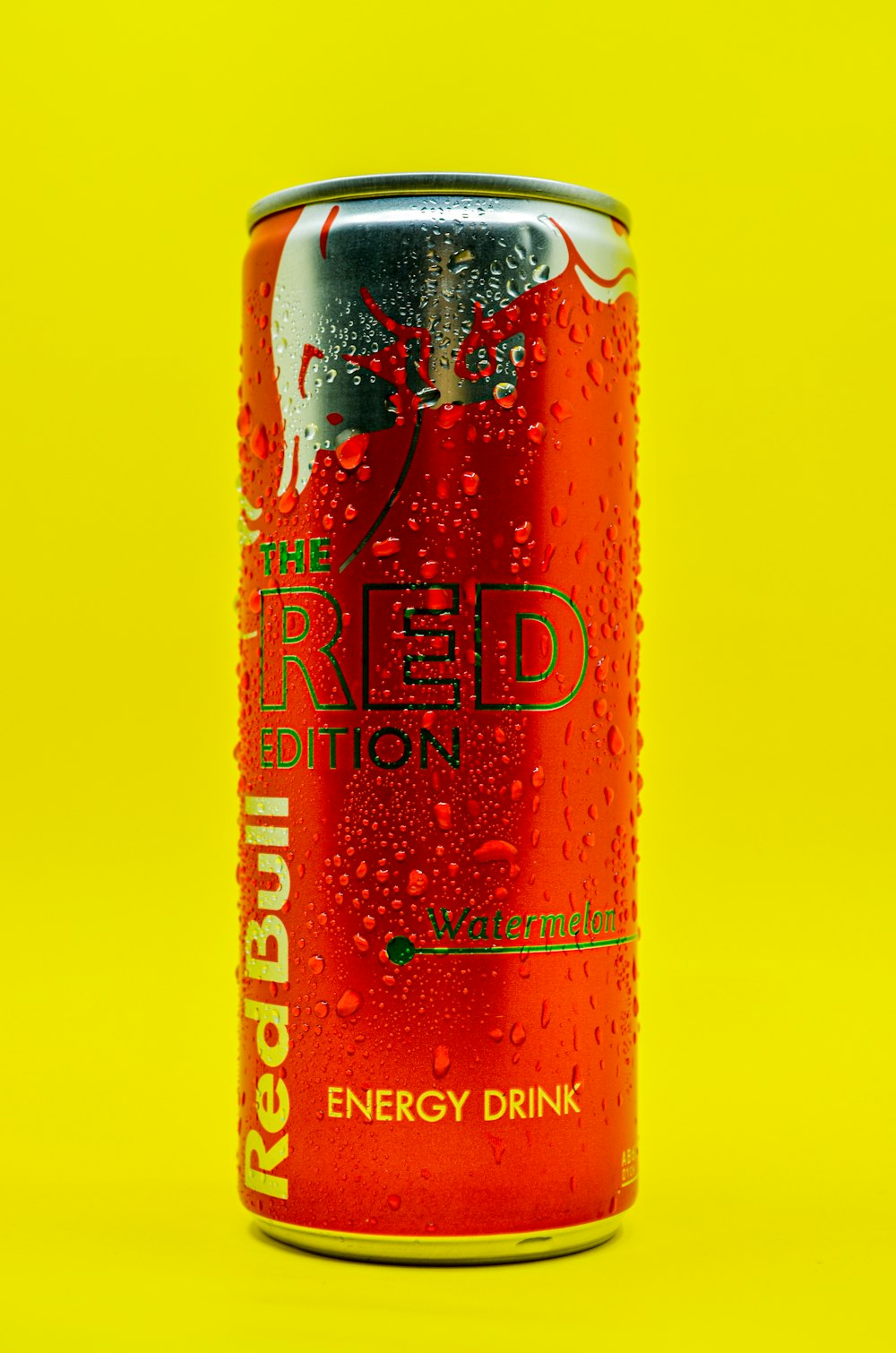 Una lata de bebida energética Red Bull sobre fondo amarillo