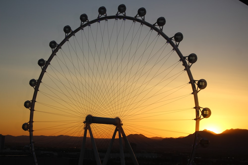 Ein Riesenrad mit der untergehenden Sonne im Hintergrund