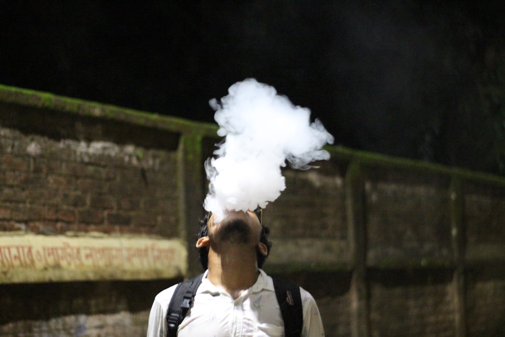 a man with a backpack and a cloud of smoke coming out of his mouth