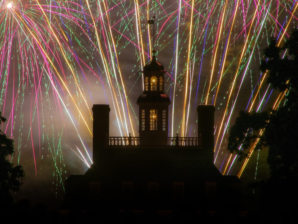 a building with a clock tower and fireworks in the sky