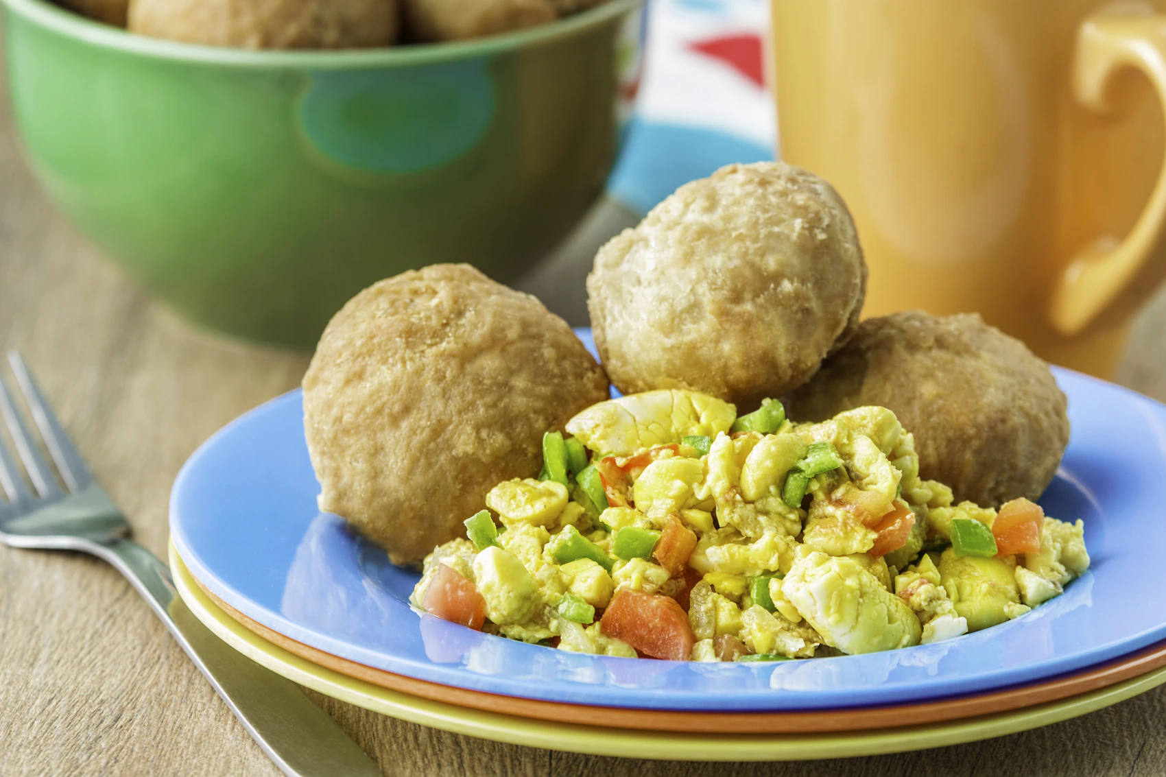 A Jamaican breakfast served on colourful plates in Kingston