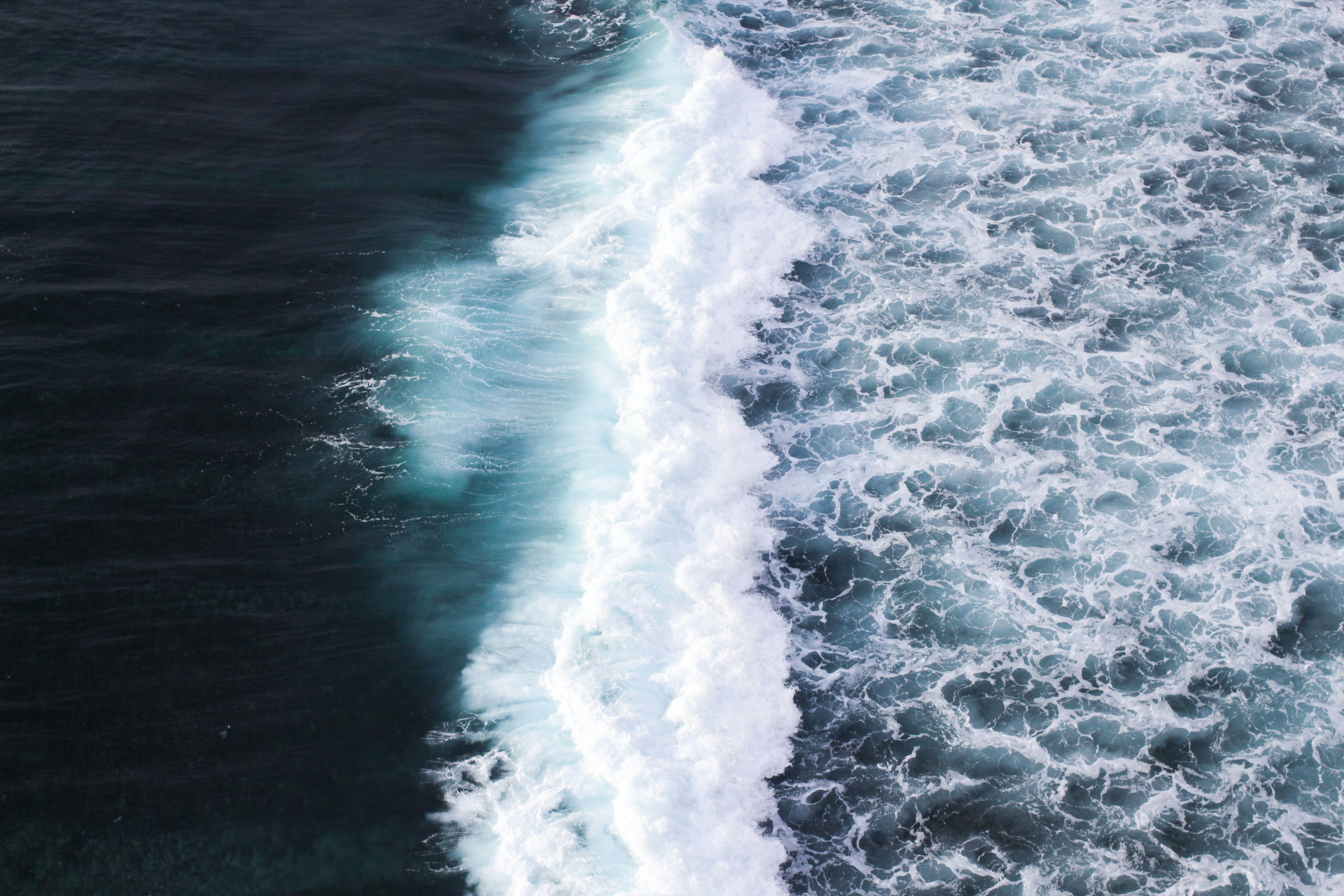 a man riding a surfboard on top of a wave in the ocean