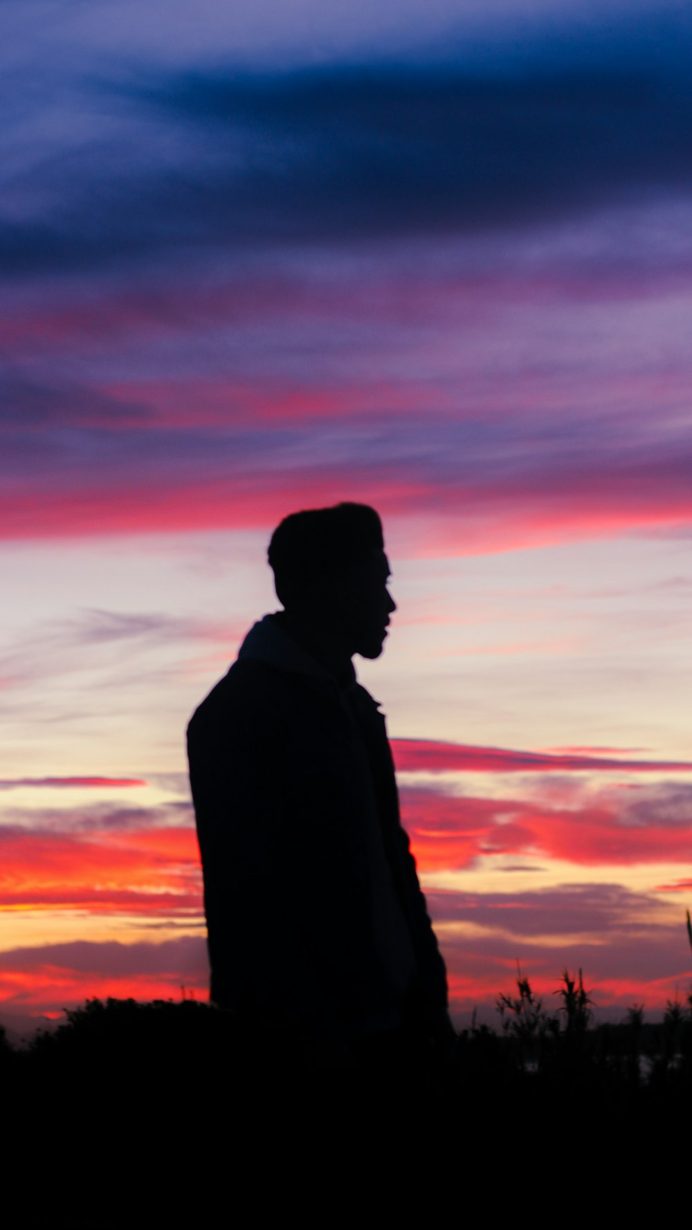 Die Silhouette eines Mannes, der vor einem Sonnenuntergang steht