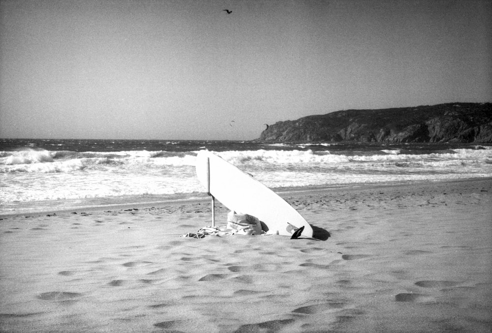 a surfboard sitting on top of a sandy beach