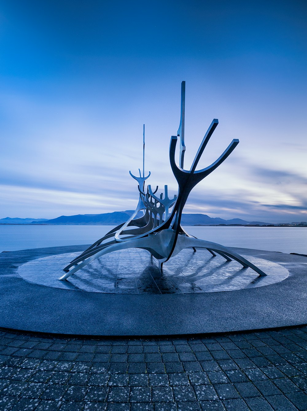 a large metal sculpture sitting on top of a sidewalk