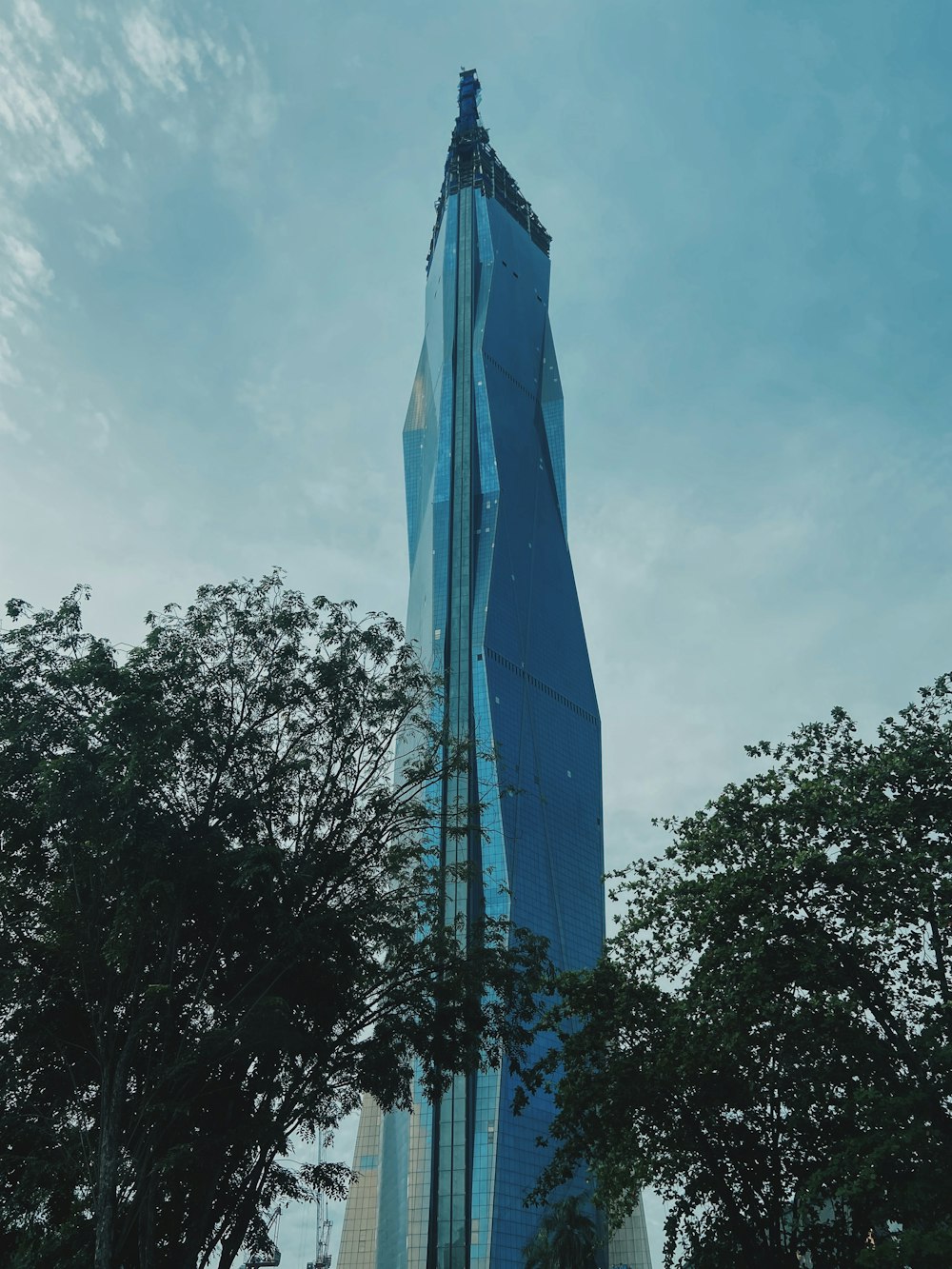 a very tall building towering over a forest of trees