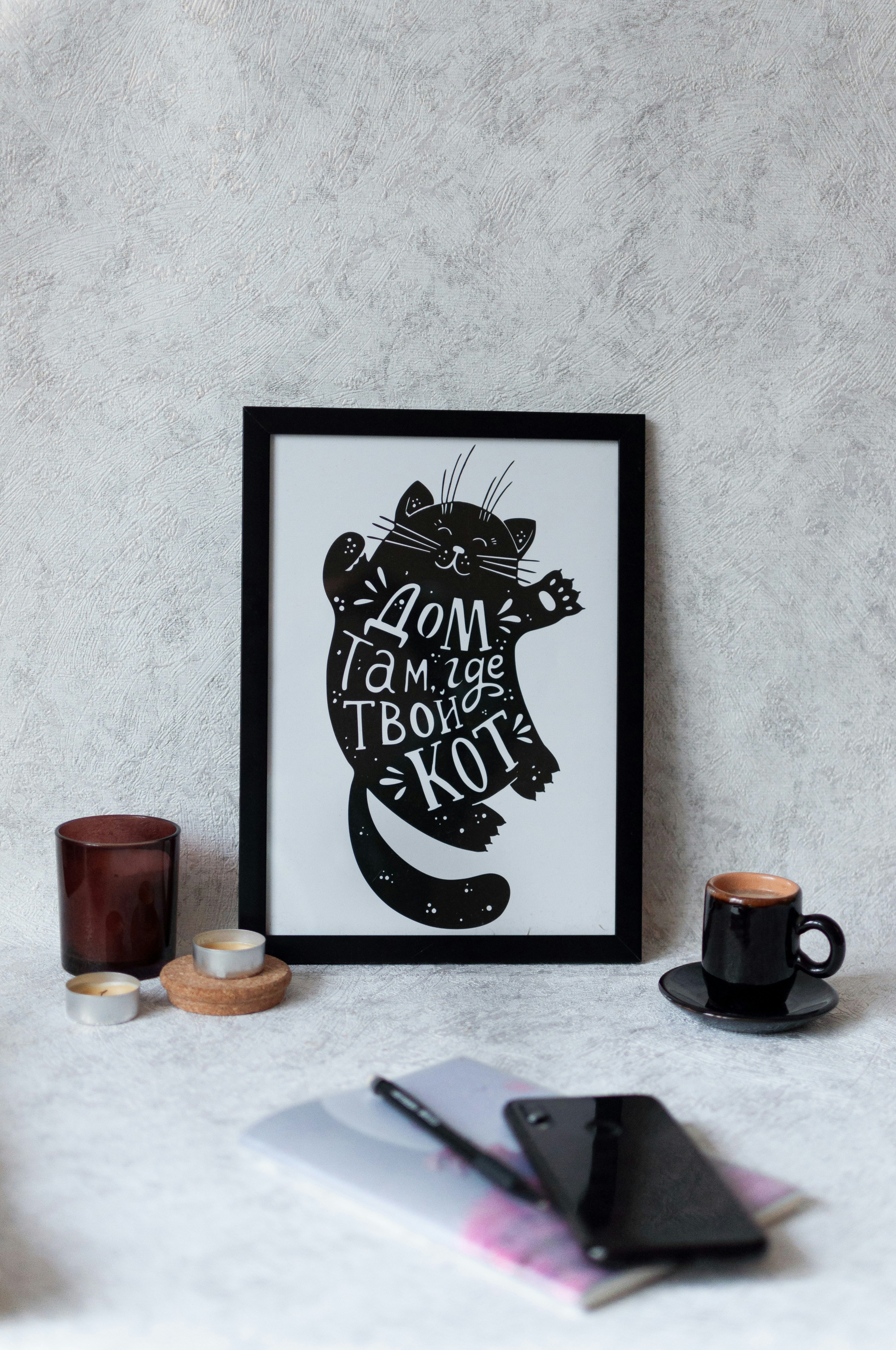 a picture of a cat on a table next to a cup of coffee